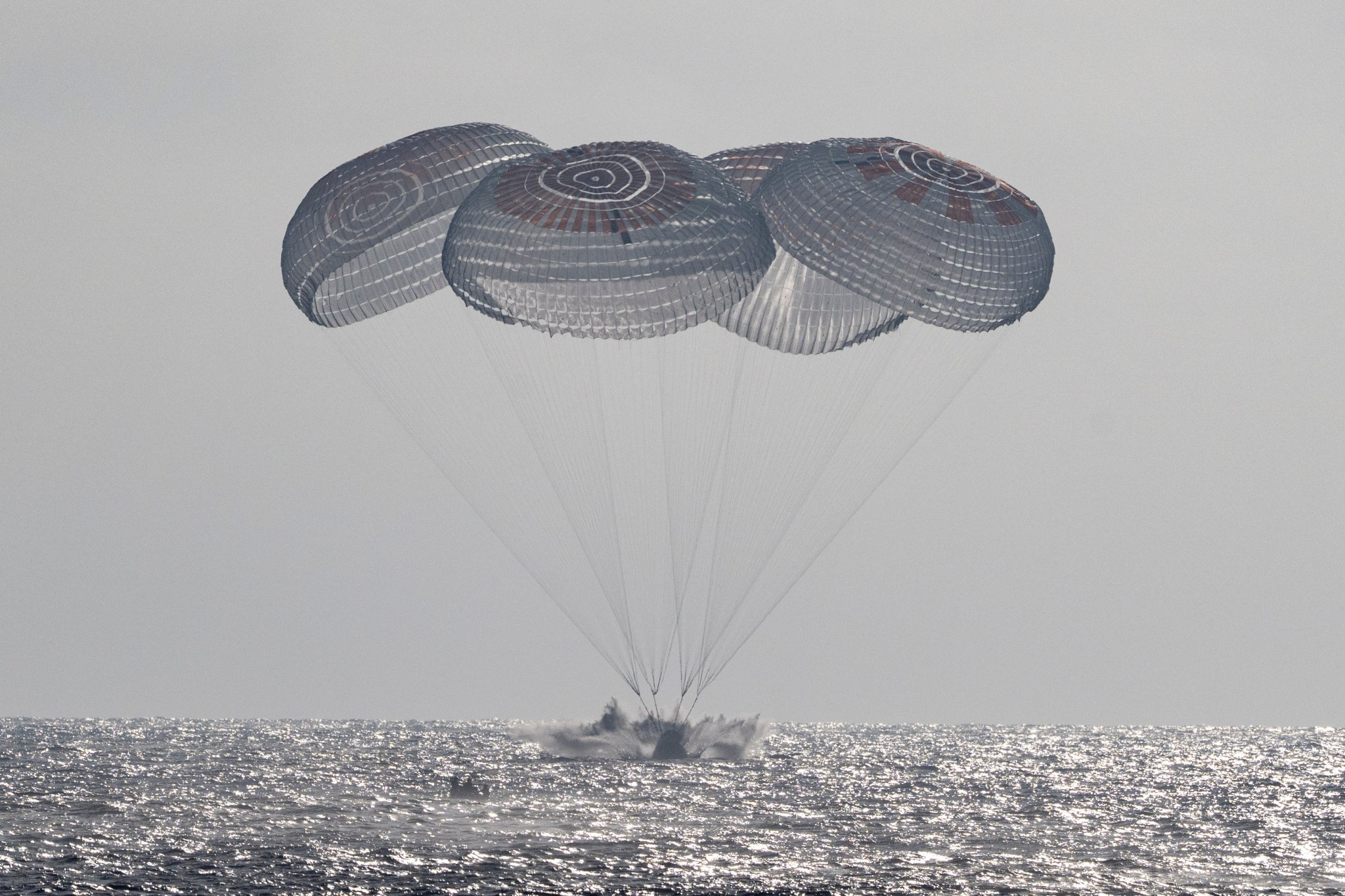 Crew-12’s Dragon spacecraft descends beneath parachutes toward the Pacific off Los Angeles on October 8, 2026.