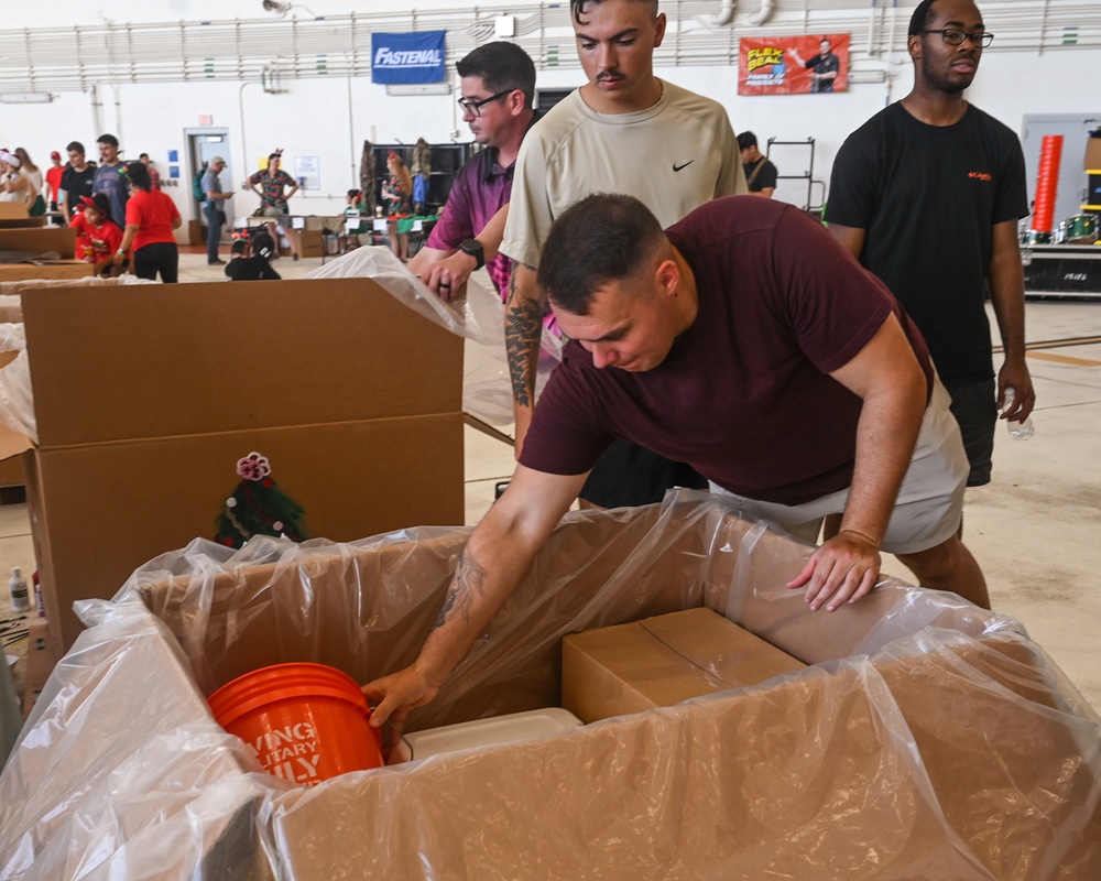 Staff Sgt. Jacob Hayes places a bucket in an Operation Christmas Drop supply bundle at Andersen Air Force Base on December 6, 2025.