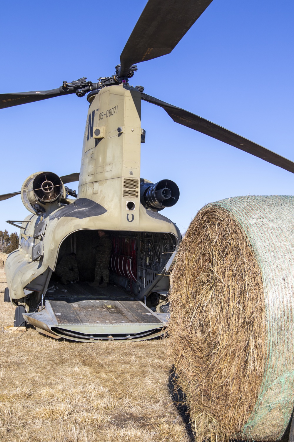Nebraska National Guard soldiers prepare hay for helicopter delivery to cattle isolated by flooding on March 20, 2019.