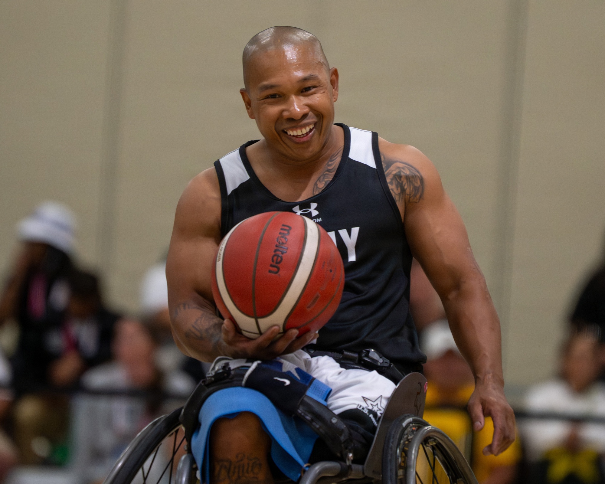Gene Calantoc smiling with a basketball in his sports wheelchair; June 2026 photograph.