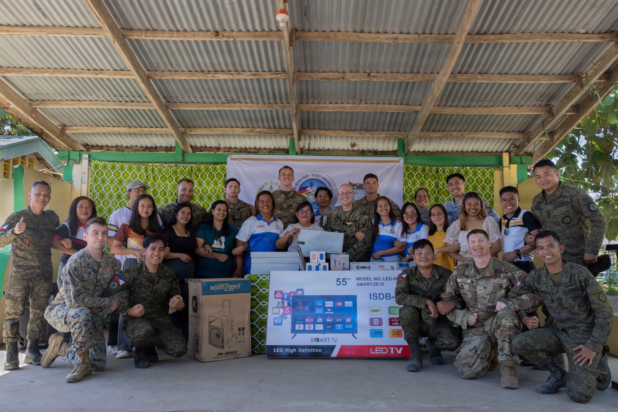 School staff and service members with classroom equipment at Villa Reyes Elementary School on April 9, 2026.